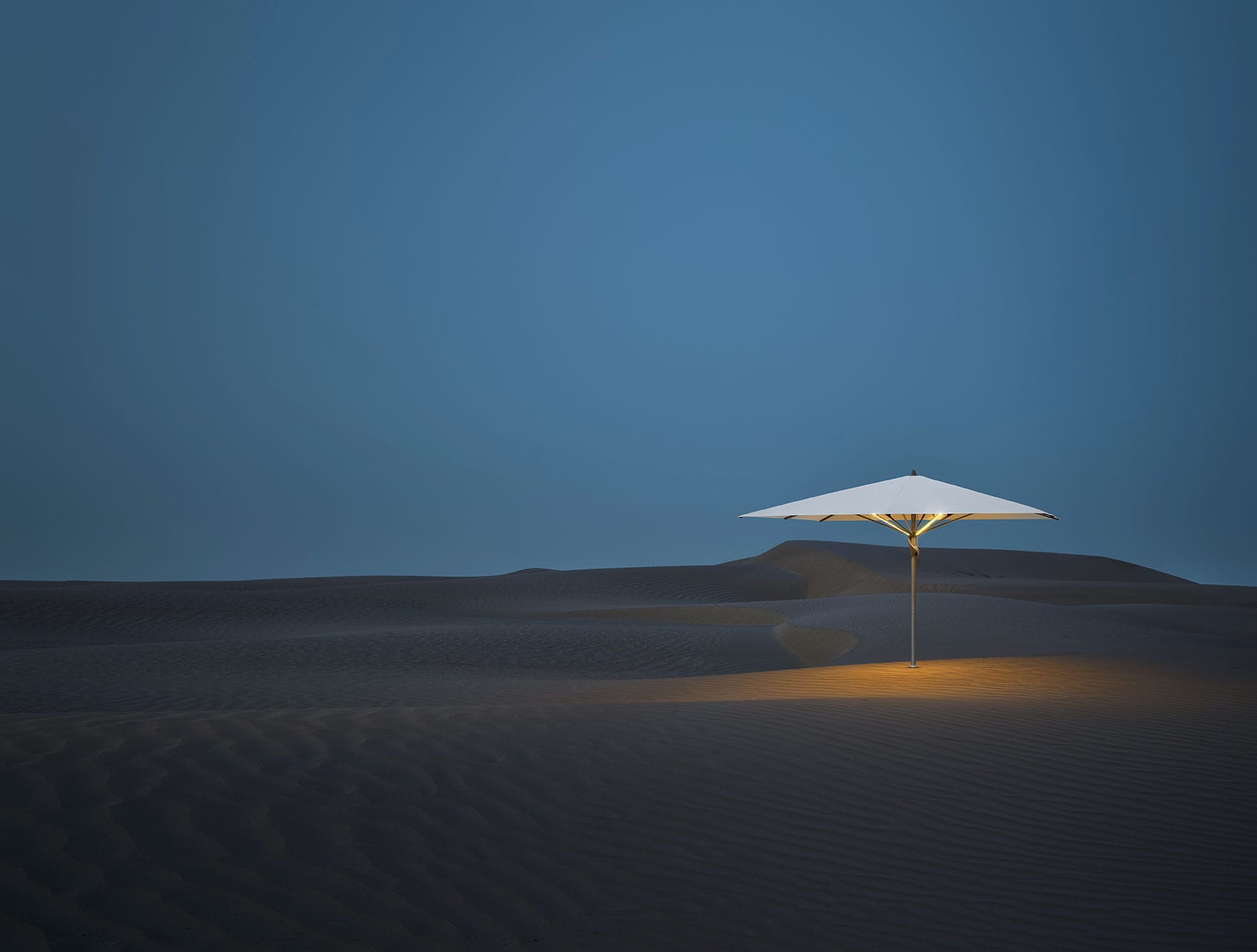 parasol au millieu du desert de nuit